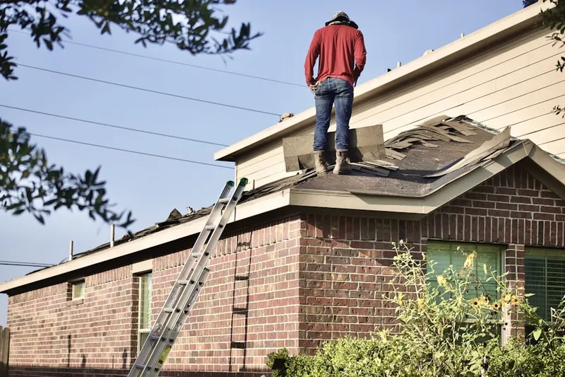 Professional roofer working on a residential roof in Alesia